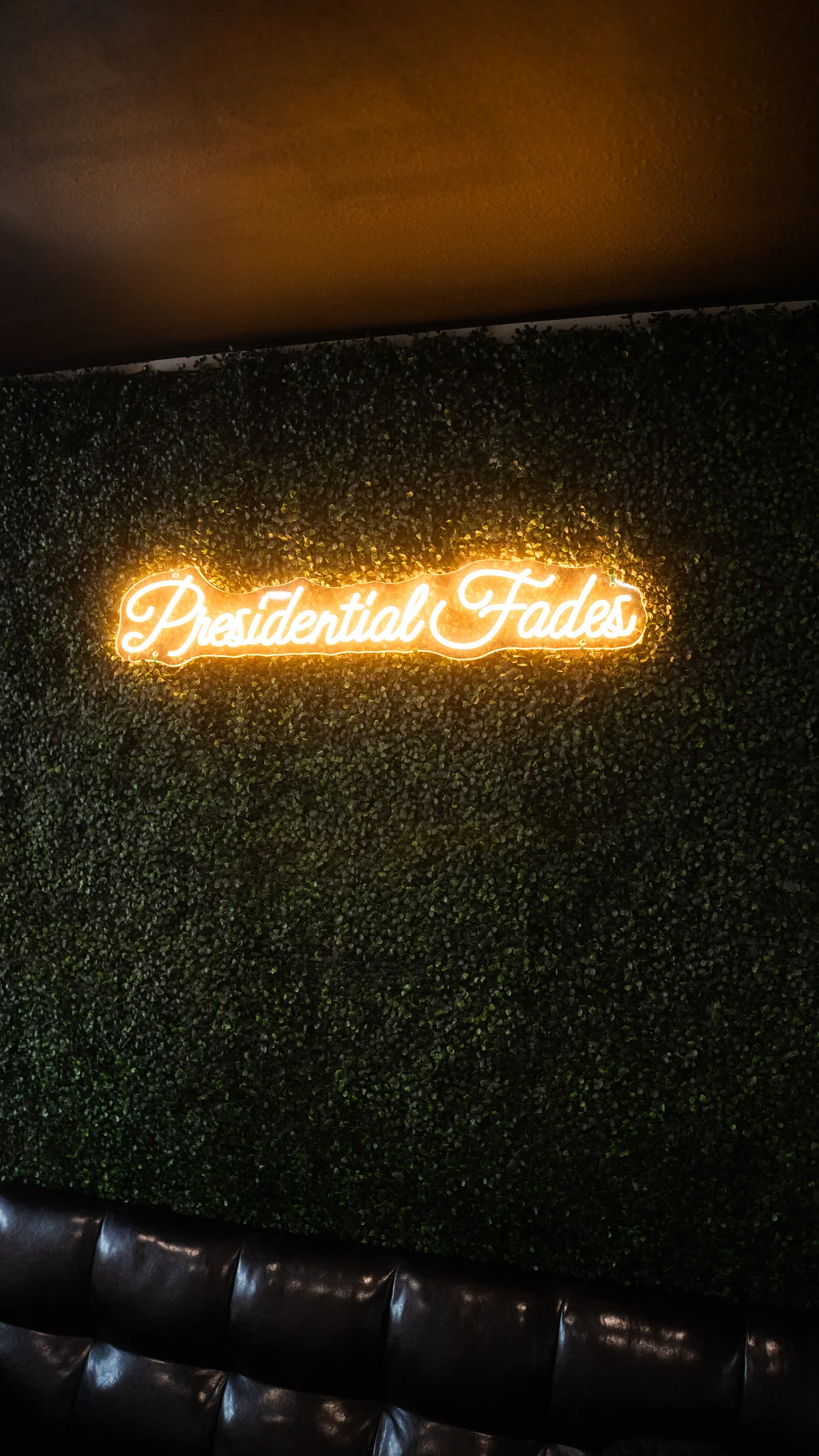 Presidential Fades neon sign on green wall